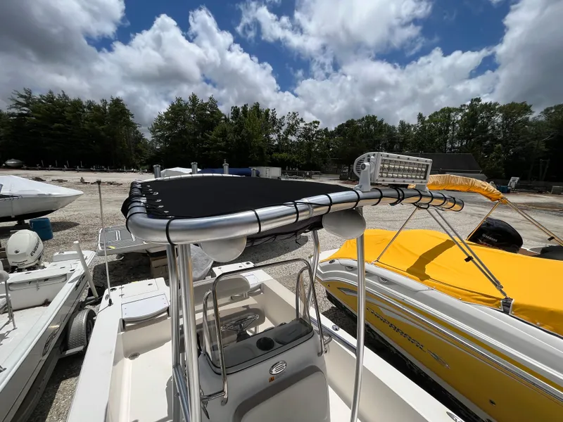 Slide: The Image of 2016 Robalo 206 Cayman boat with T-top and LED light, parked outdoors under cloudy sky. - 34