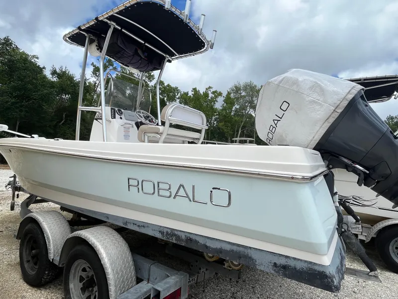 Slide: The Image of 2016 Robalo 206 Cayman boat on trailer, featuring outboard motor and canopy, parked outdoors. - 5