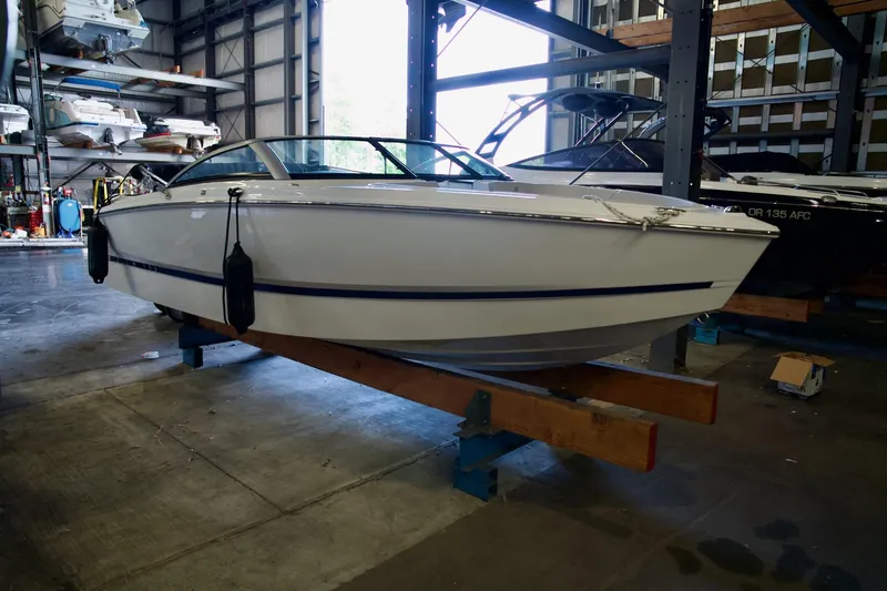 The Image of 2026 Four Winns H1 boat in indoor storage, resting on wooden supports. - 1