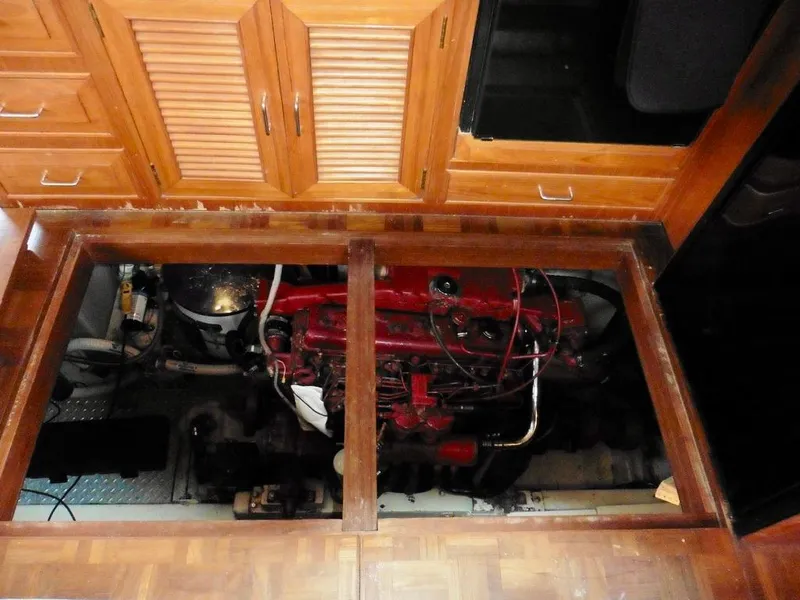 Slide: The Image of Engine room of 1984 Ocean Alexander 38 Double Cabin yacht, featuring red engine and wooden cabinetry. - 14