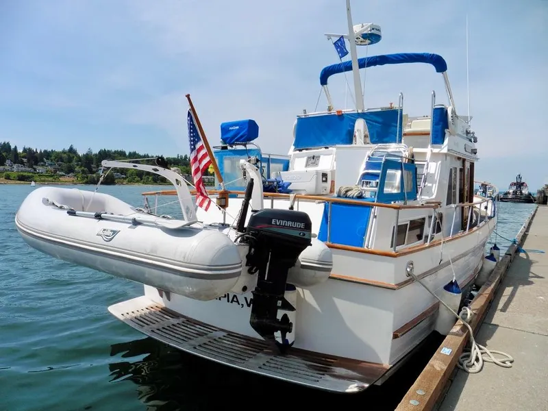 Slide: The Image of 1984 Ocean Alexander 38 Double Cabin yacht docked with inflatable boat and American flag. - 2