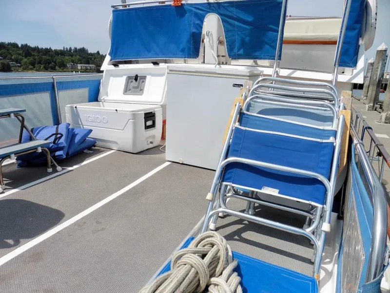 Slide: The Image of 1984 Ocean Alexander 38 Double Cabin deck with blue chairs and cooler. - 4