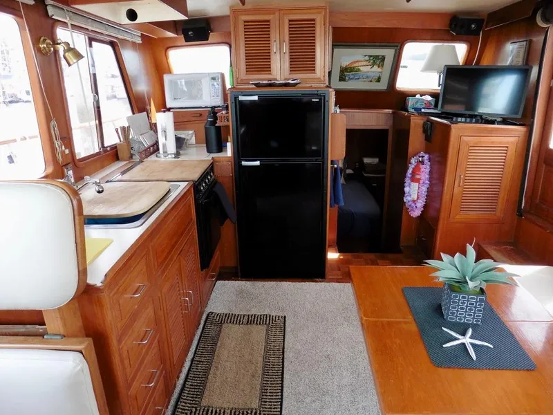 Slide: The Image of 1984 Ocean Alexander 38 Double Cabin interior with kitchen, dining area, and decor. - 6