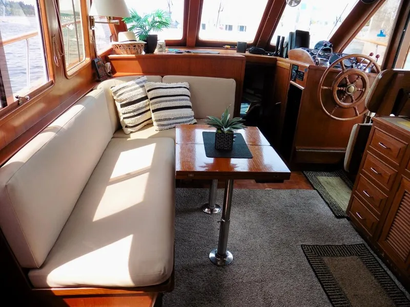Slide: The Image of 1984 Ocean Alexander 38 Double Cabin interior with cozy seating, wooden table, and helm station. - 7