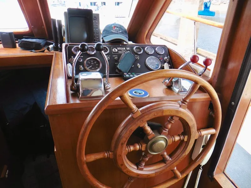 Slide: The Image of 1984 Ocean Alexander 38 Double Cabin helm with wooden wheel and navigation instruments. - 8