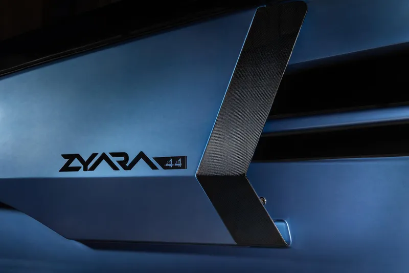 Slide: The Image of Close-up of 2025 Introductory ZYARA 44 logo on sleek blue surface. - 3