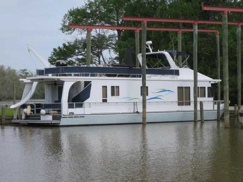 Slide: The Image of 1998 Monticello River Yacht Houseboat docked on a calm river. - 0