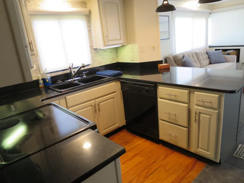 Slide: The Image of 1998 Monticello River Yacht Houseboat kitchen with black countertops and white cabinets. - 14
