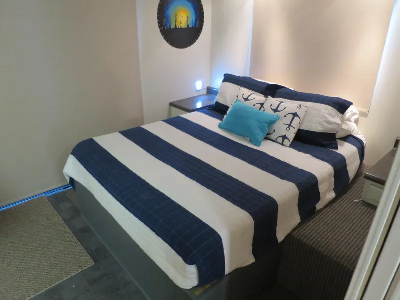 Slide: The Image of 1998 Monticello River Yacht Houseboat bedroom with nautical-themed bedding. - 17