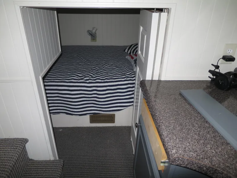 Slide: The Image of 1998 Monticello River Yacht Houseboat interior bedroom with striped bedding. - 21