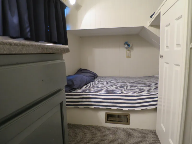 Slide: The Image of 1998 Monticello River Yacht Houseboat cozy bedroom with striped bedding. - 23