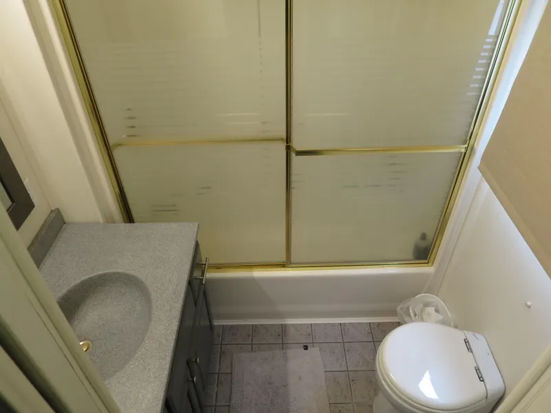 Slide: The Image of Bathroom in a 1998 Monticello River Yacht Houseboat with shower, sink, and toilet. - 26