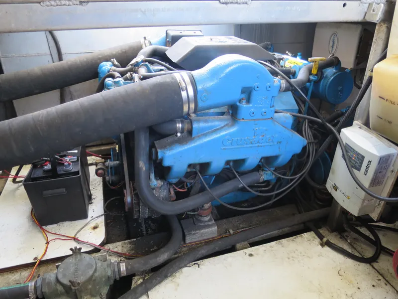 Slide: The Image of 1998 Monticello River Yacht Houseboat engine compartment with blue engine and battery. - 29