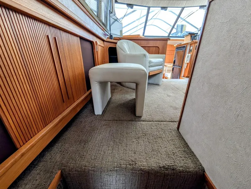 Slide: The Image of Interior of 1991 Carver 430 Cockpit Motor Yacht with wooden paneling and white seating. - 24