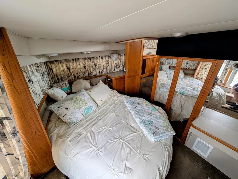 Slide: The Image of Cozy bedroom in 1991 Carver 430 Cockpit Motor Yacht with wood accents and plush bedding. - 27