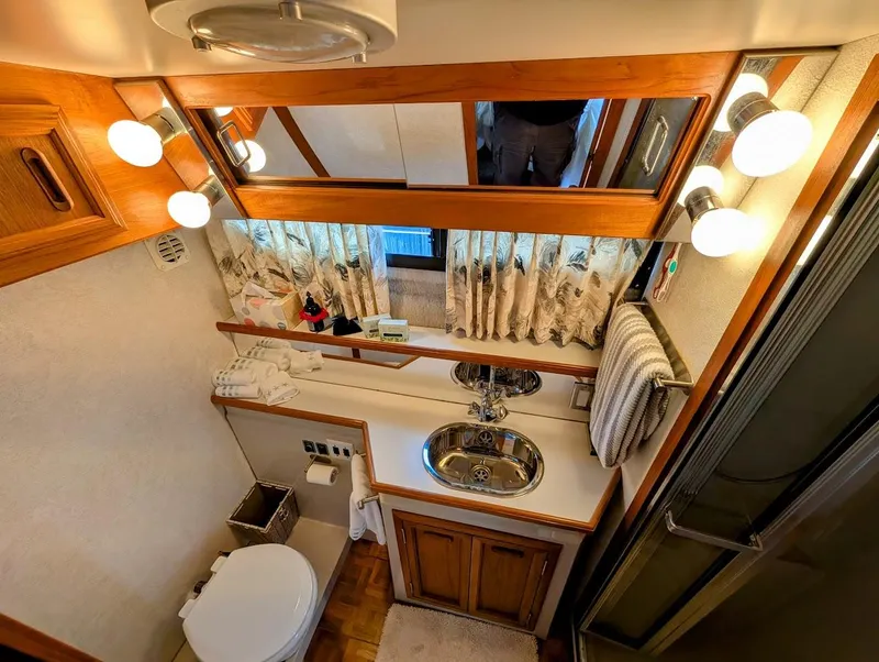 Slide: The Image of Luxurious bathroom in 1991 Carver 430 Cockpit Motor Yacht with elegant fixtures and ample lighting. - 29