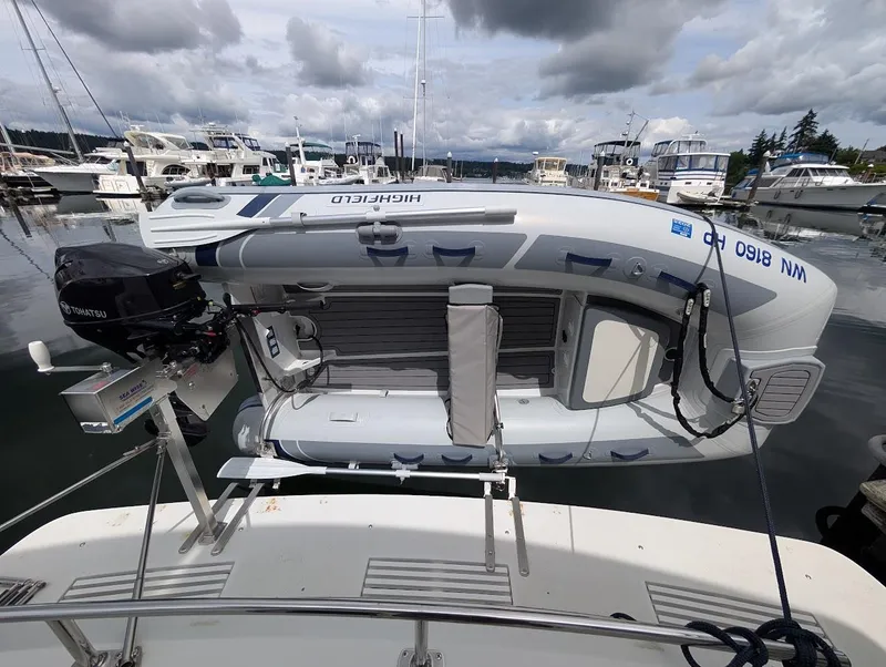 Slide: The Image of Inflatable boat on Carver 430 Cockpit Motor Yacht, 1991, docked at marina under cloudy sky. - 45