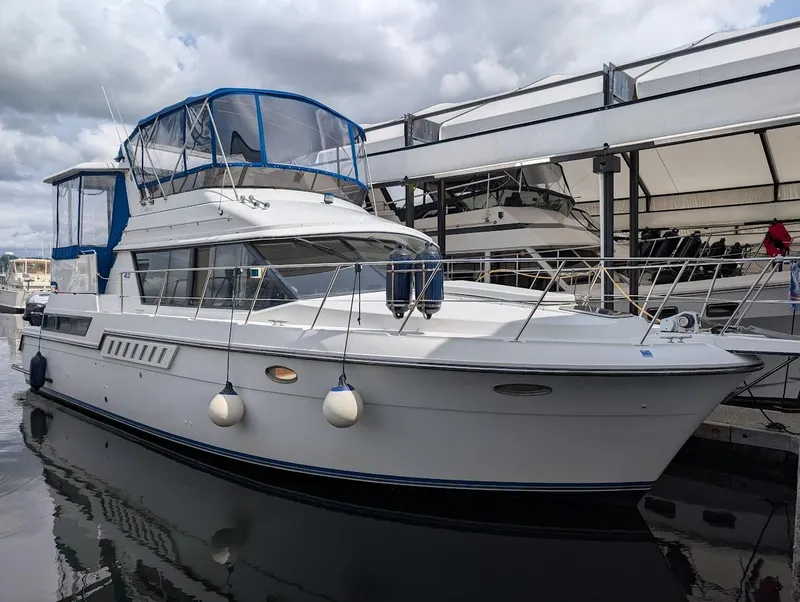 The Image of 1991 Carver 430 Cockpit Motor Yacht docked at marina under cloudy skies. - 0