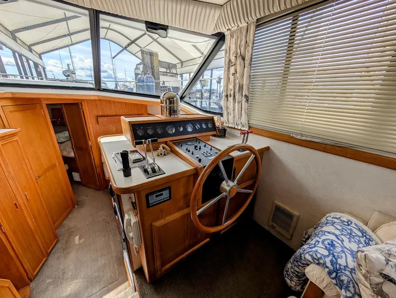 Slide: The Image of 1991 Carver 430 Cockpit Motor Yacht helm with wooden steering wheel and control panel. - 10