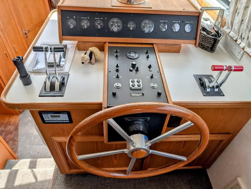 Slide: The Image of Interior helm of 1991 Carver 430 Cockpit Motor Yacht with steering wheel and control panel. - 11