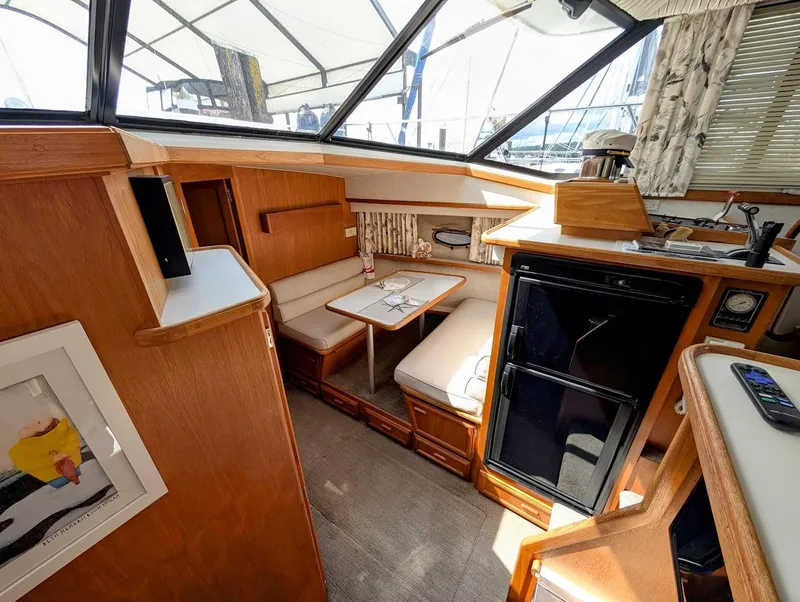 Slide: The Image of Interior of 1991 Carver 430 Cockpit Motor Yacht with seating, table, and kitchenette. - 12