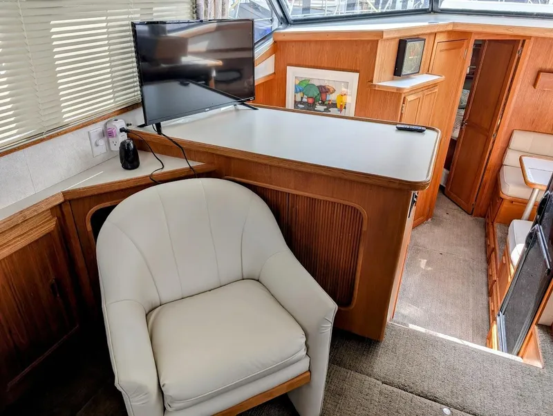 Slide: The Image of Interior of 1991 Carver 430 Cockpit Motor Yacht with chair, TV, and wooden cabinetry. - 13