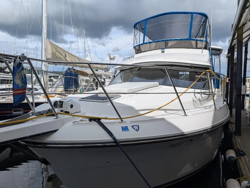 Slide: The Image of 1991 Carver 430 Cockpit Motor Yacht docked at marina under cloudy sky. - 2