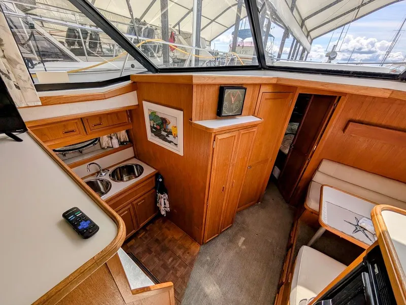 Slide: The Image of 1991 Carver 430 Cockpit Motor Yacht interior with kitchenette, seating, and wood cabinetry. - 23