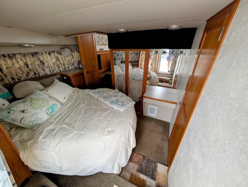 Slide: The Image of Cozy bedroom in 1991 Carver 430 Cockpit Motor Yacht with plush bedding and wooden accents. - 28