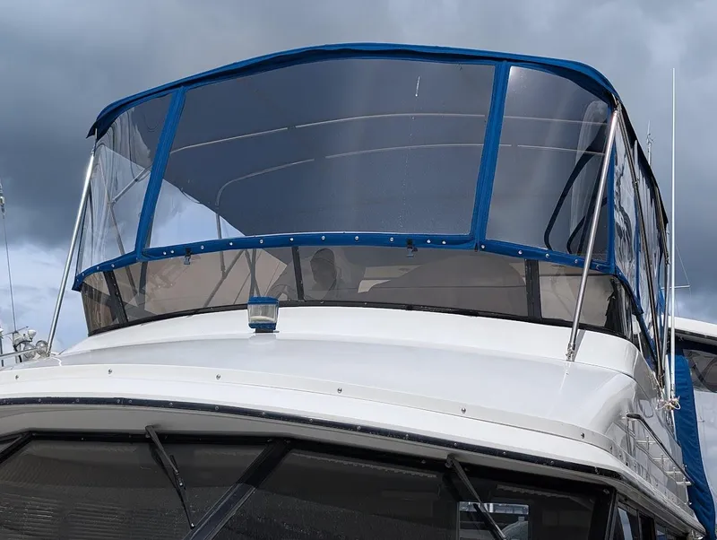 Slide: The Image of 1991 Carver 430 Cockpit Motor Yacht with blue canopy under cloudy sky. - 3