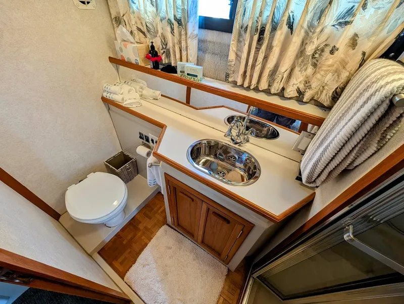 Slide: The Image of Bathroom interior of 1991 Carver 430 Cockpit Motor Yacht, featuring sink and toilet. - 30
