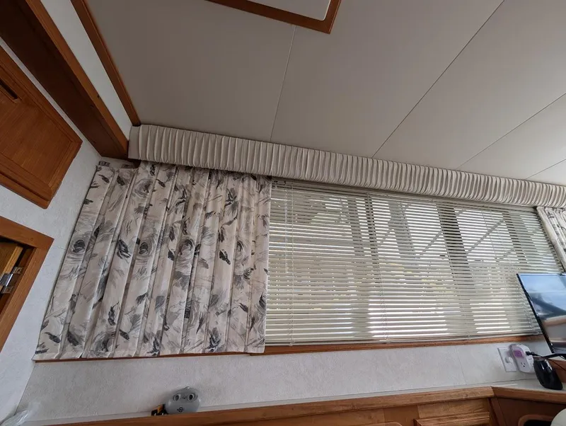 Slide: The Image of Interior of 1991 Carver 430 Cockpit Motor Yacht with floral curtains and blinds. - 33