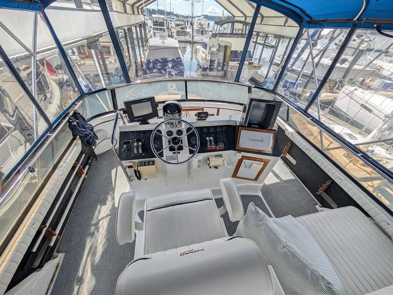 Slide: The Image of 1991 Carver 430 Cockpit Motor Yacht helm with navigation equipment and marina view. - 34
