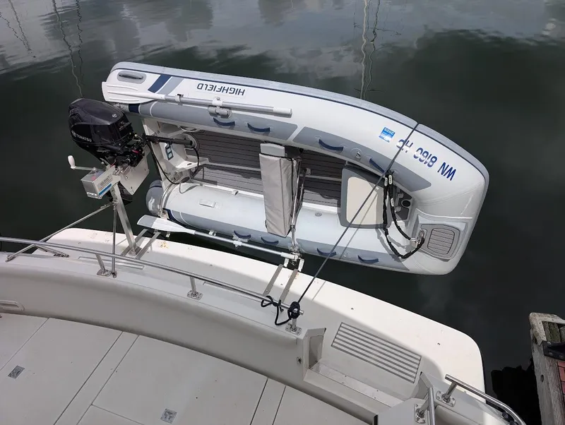 Slide: The Image of 1991 Carver 430 Cockpit Motor Yacht with attached inflatable boat and outboard motor. - 44