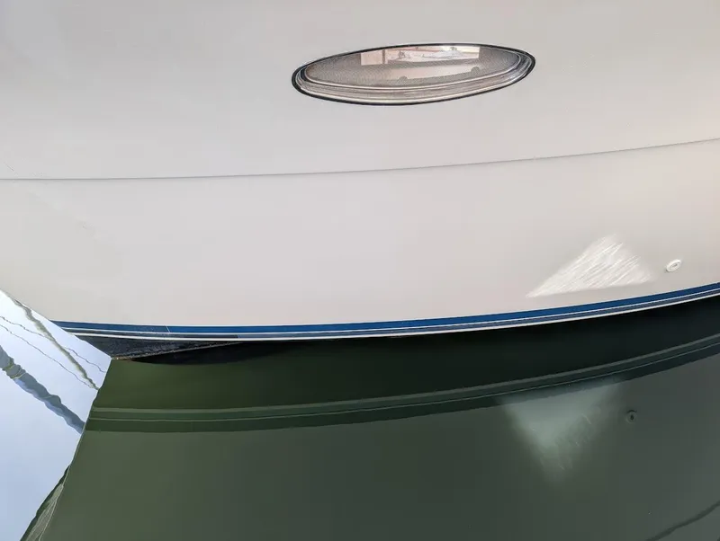 Slide: The Image of Close-up of a 1991 Carver 430 Cockpit Motor Yacht hull reflecting on water. - 46