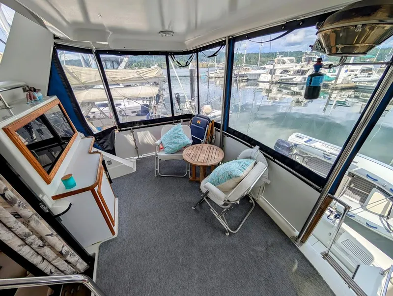 Slide: The Image of 1991 Carver 430 Cockpit Motor Yacht interior with seating and marina view. - 7