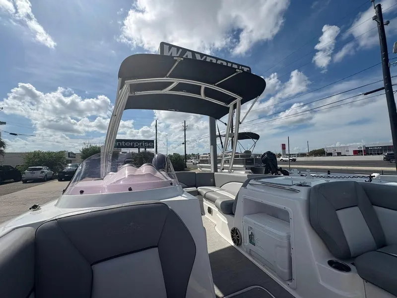 Slide: The Image of 2021 NauticStar 203 SC boat with canopy, parked under a blue sky with clouds. - 10