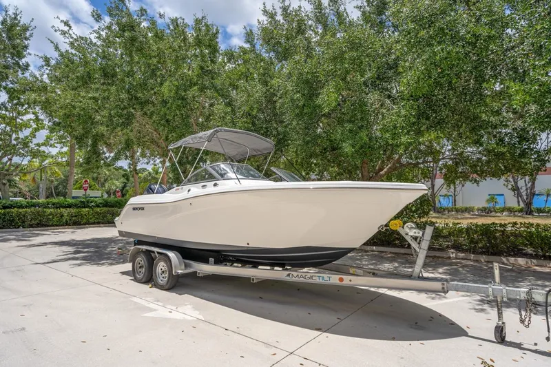 Slide: The Image of 2025 Sea Fox 228 Traveler boat on trailer, parked outdoors with trees in background. - 4