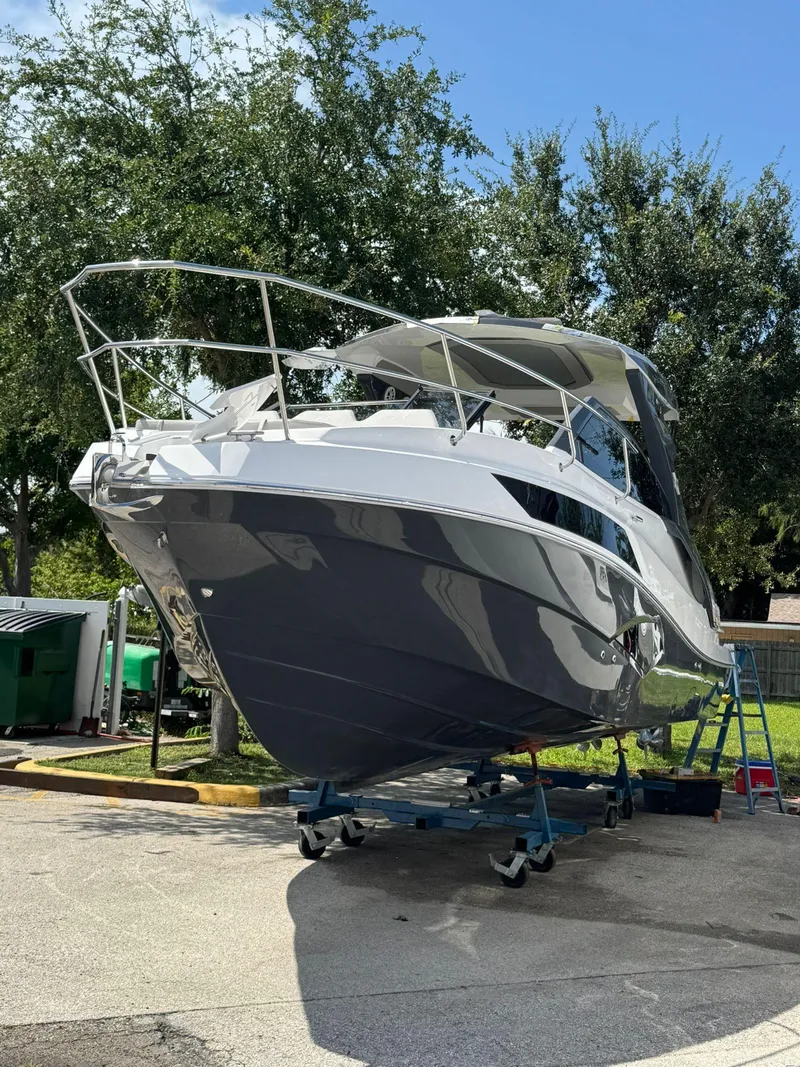 Slide: The Image of 2025 NX Boats NX340 on trailer, sleek design, parked outdoors under clear sky. - 3