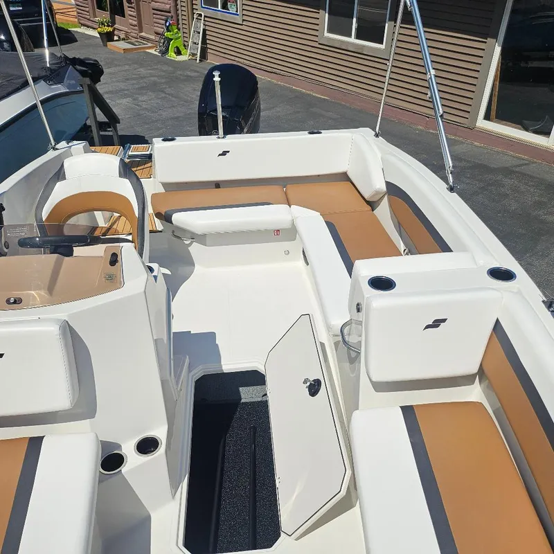 Slide: The Image of 2026 Starcraft SVX 171 OB boat interior with tan and white seating, open storage compartment. - 10