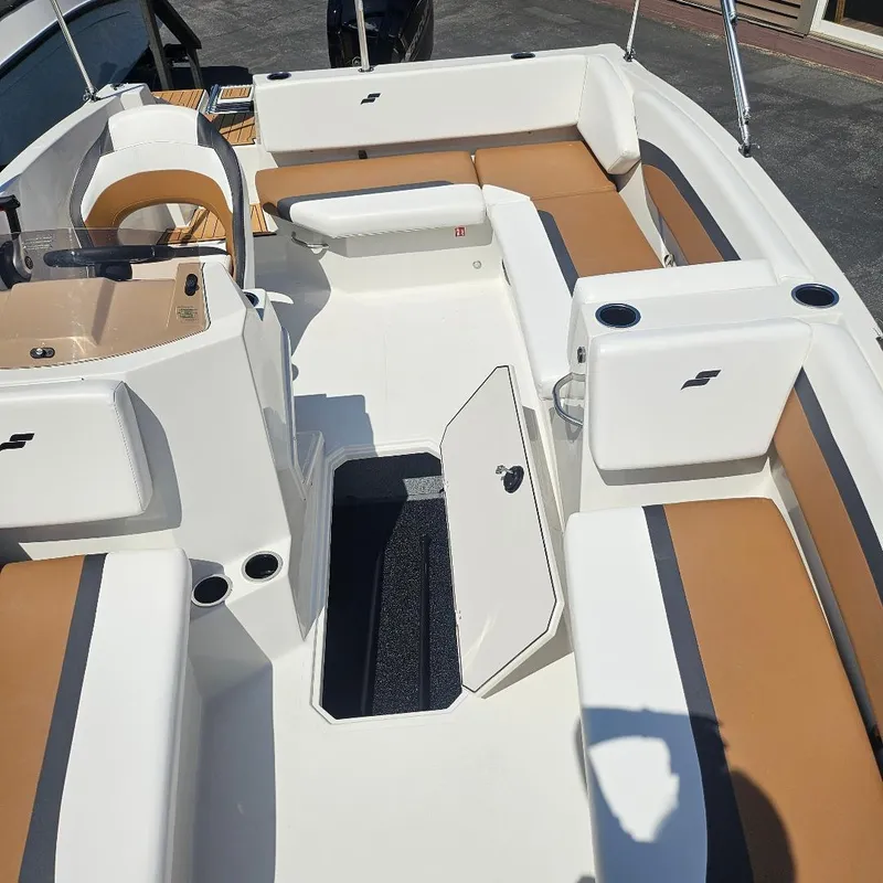 Slide: The Image of 2026 Starcraft SVX 171 OB boat interior with tan and white seating, open storage compartment. - 11