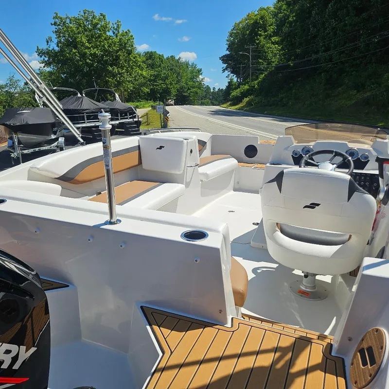 Slide: The Image of 2026 Starcraft SVX 171 OB boat interior with seating, steering wheel, and outboard motor. - 13