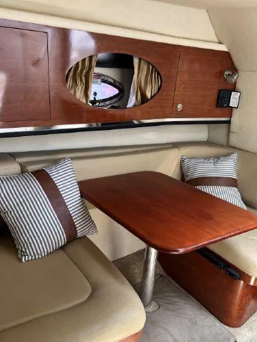 Slide: The Image of 2007 Sea Ray 290 Amberjack cabin interior with wood finish and striped cushions. - 8