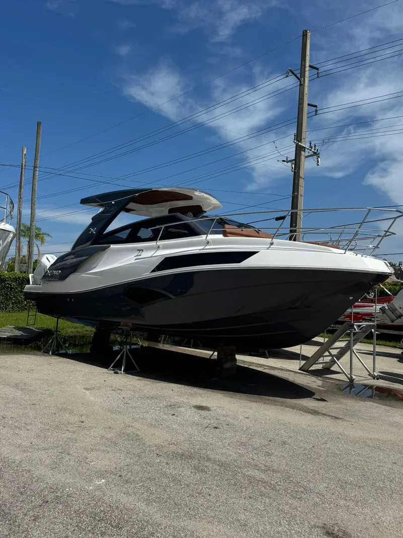 Slide: The Image of 2025 NX Boats NX340 yacht on stands, sleek design, sunny day, blue sky background. - 4
