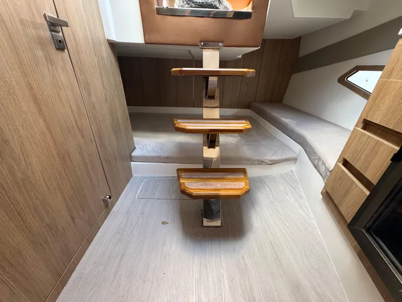 Slide: The Image of Interior of 2025 NX Boats NX340, featuring wooden steps and modern cabin design. - 8