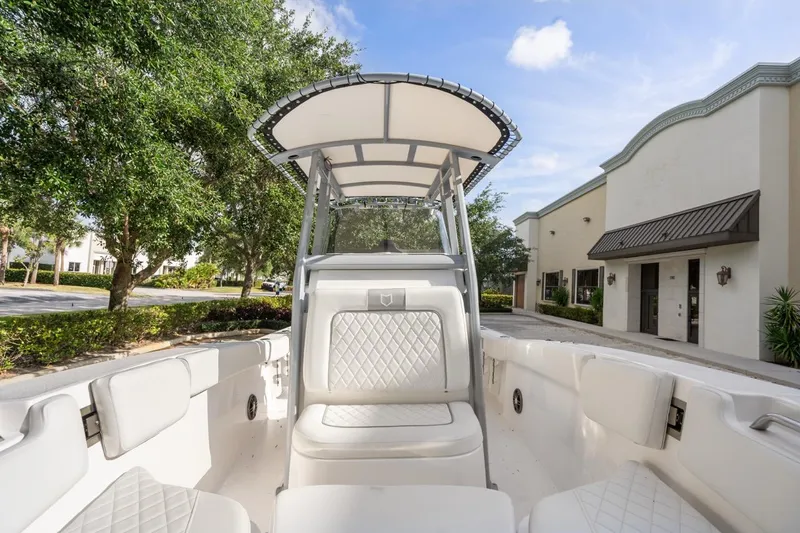 Slide: The Image of 2025 Sea Fox 228 Commander boat with white interior, parked near buildings and trees. - 13