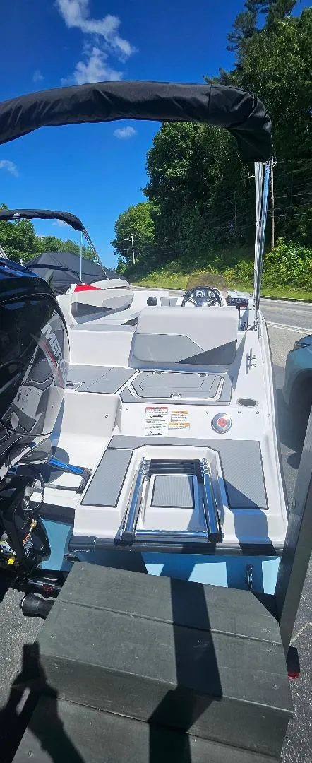 Slide: The Image of 2026 Starcraft SV 16 OB boat on trailer, sunny day, surrounded by trees and road. - 13