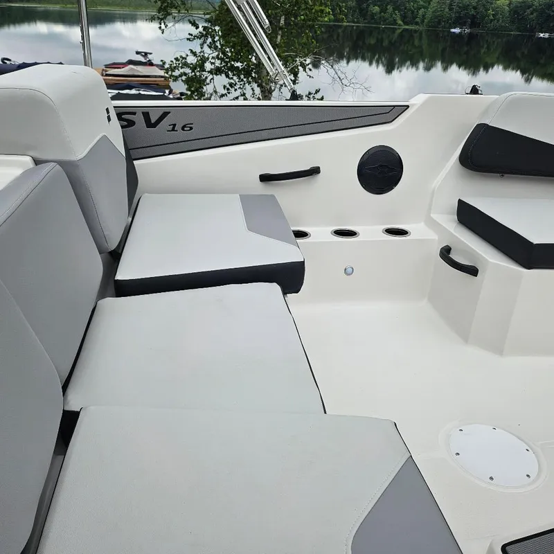 Slide: The Image of 2026 Starcraft SV 16 OB boat interior with gray seating, cup holders, and lake view. - 3