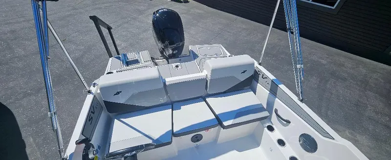 Slide: The Image of 2026 Starcraft SV 16 OB boat interior with seating and motor, parked on pavement. - 6