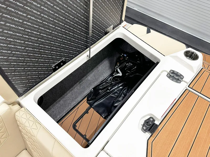Slide: The Image of 2026 Nautique GS24 boat storage compartment with open lid, showcasing interior space and design. - 10